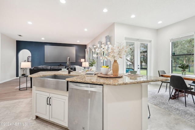 kitchen with dishwasher, white cabinetry, sink, and an island with sink