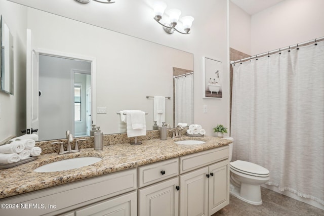 bathroom with toilet, vanity, and tile patterned floors