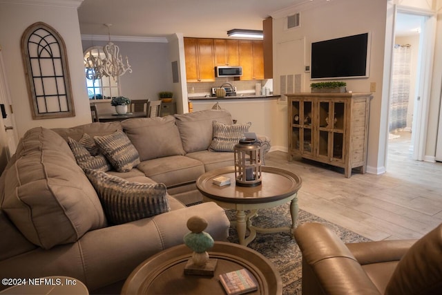 21 Arbor Club Dr Unit 101, Ponte Vedra Beach, FL 32082 - living area featuring an inviting chandelier, baseboards, light wood-type flooring, visible vents, and ornamental molding