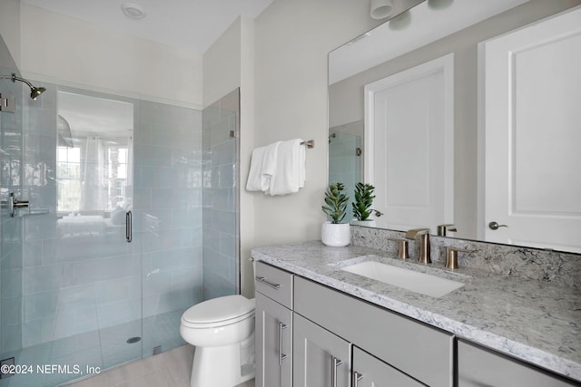 bathroom with vanity, toilet, and an enclosed shower