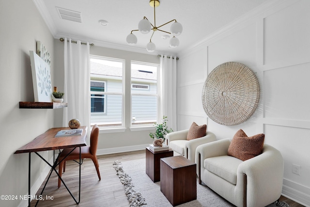 sitting room with ornamental molding, a chandelier, and hardwood / wood-style flooring