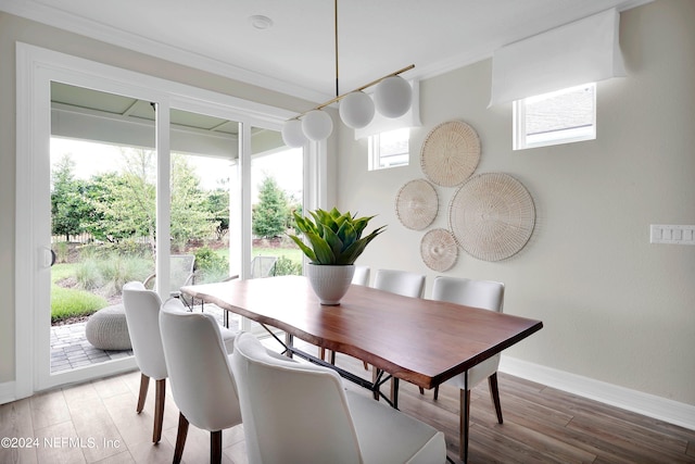 dining area featuring crown molding, hardwood / wood-style floors, and plenty of natural light