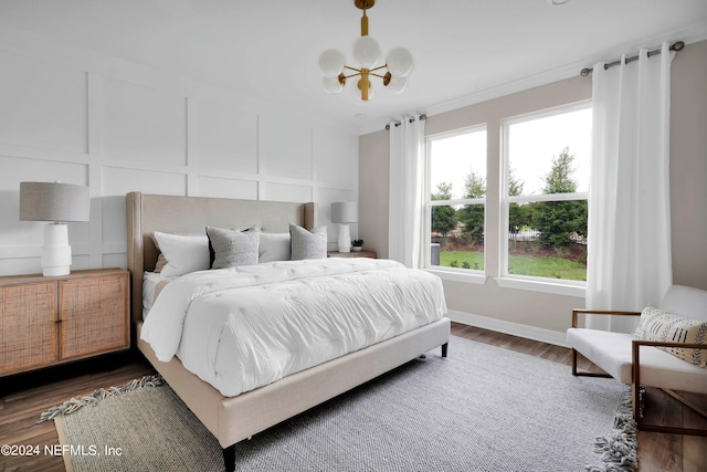 bedroom with dark hardwood / wood-style floors and a chandelier