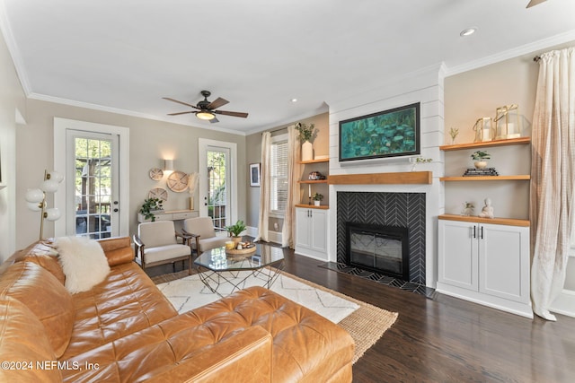 living room featuring dark hardwood / wood-style flooring, ceiling fan, ornamental molding, and a fireplace