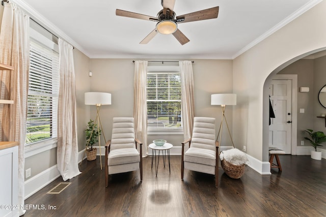 living area with dark wood-type flooring, ceiling fan, and crown molding