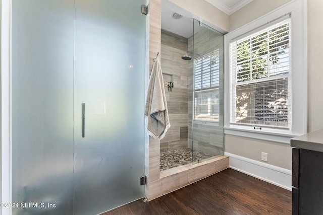 bathroom featuring hardwood / wood-style floors, crown molding, and a shower with door