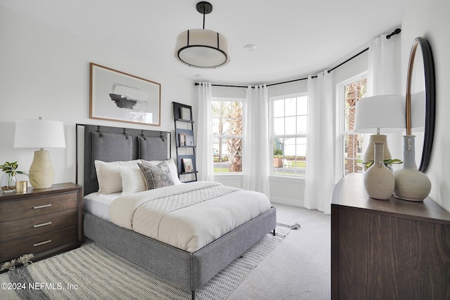 bedroom with light carpet and multiple windows