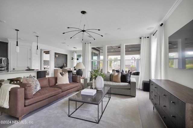 living room with light hardwood / wood-style floors, crown molding, and a chandelier