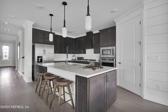 kitchen with a center island with sink, light wood-type flooring, stainless steel appliances, crown molding, and sink