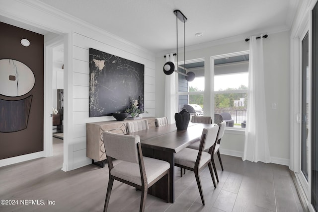 dining room with ornamental molding and wood-type flooring