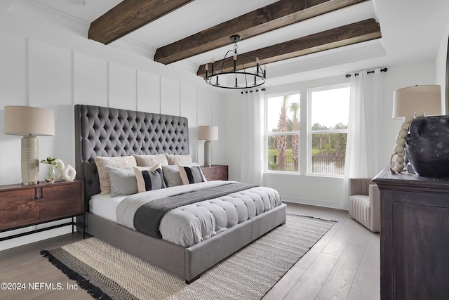 bedroom with an inviting chandelier, beamed ceiling, and light wood-type flooring