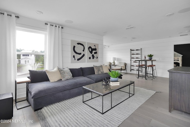 living room featuring wooden walls and light wood-type flooring