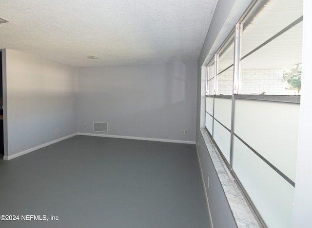 empty room featuring concrete flooring and a textured ceiling