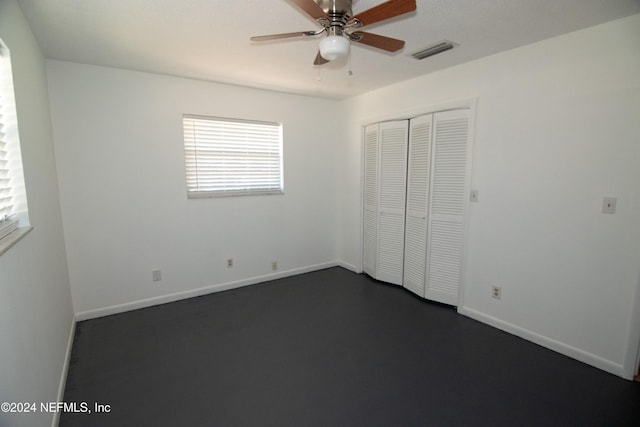 unfurnished bedroom with ceiling fan and a closet