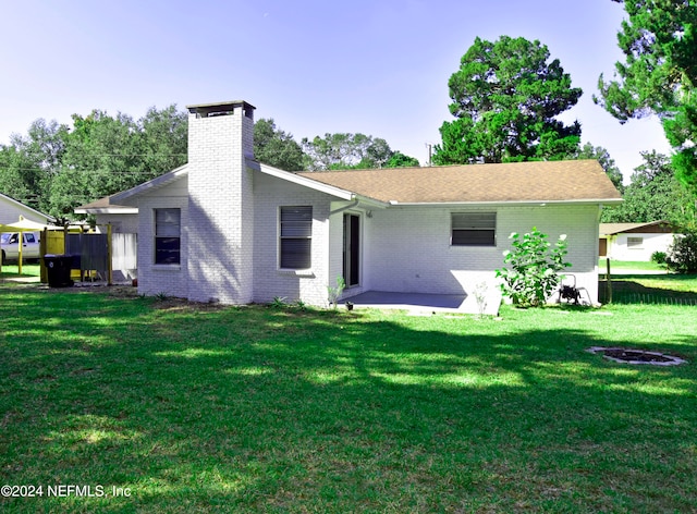 rear view of house featuring a yard and a patio area