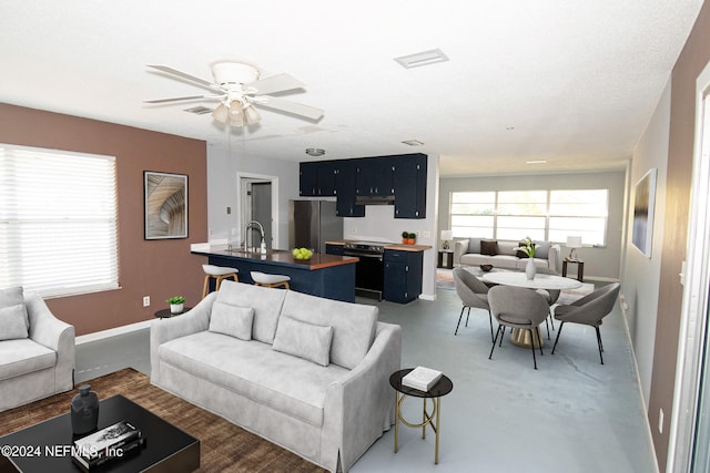 living room with ceiling fan and sink