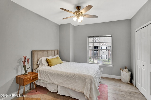 bedroom with a closet, ceiling fan, baseboards, and wood finished floors