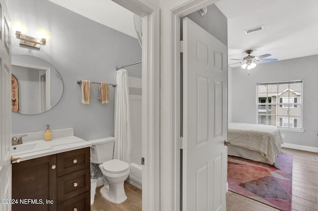 ensuite bathroom with visible vents, toilet, ensuite bath, wood finished floors, and vanity