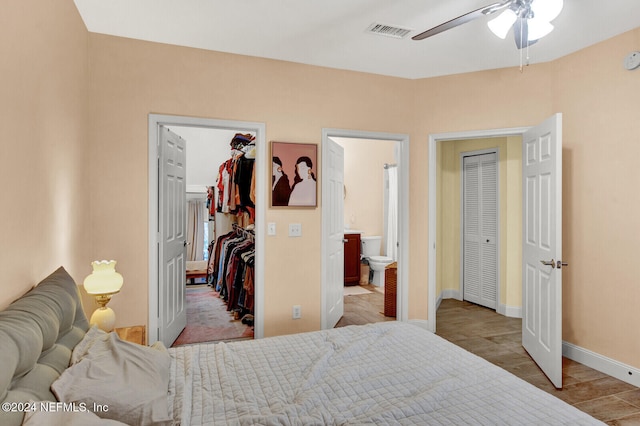 bedroom featuring a walk in closet, connected bathroom, and ceiling fan