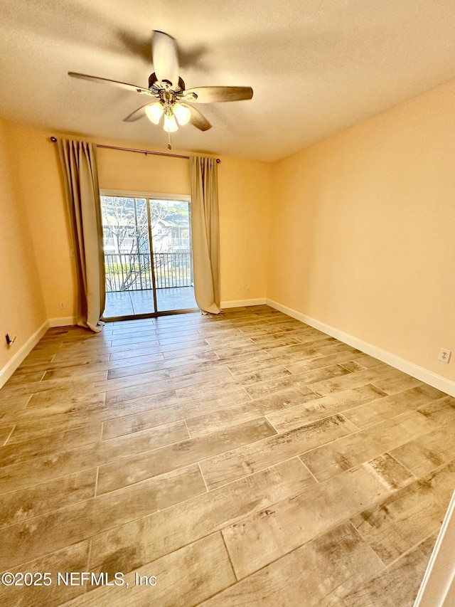 spare room featuring ceiling fan, a textured ceiling, wood finished floors, and baseboards