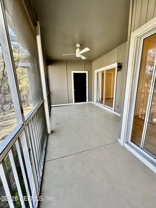 unfurnished sunroom featuring a ceiling fan