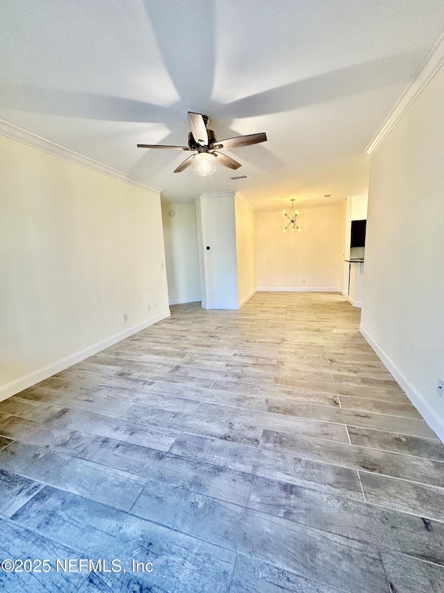 spare room featuring ceiling fan, ornamental molding, wood finished floors, and baseboards