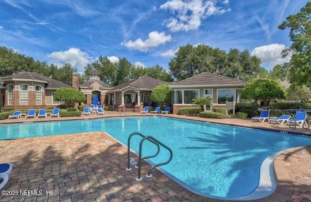 pool with a patio area and fence