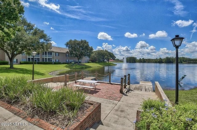 view of home's community with a lawn and a water view