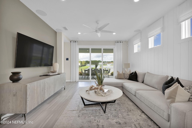 living room with light hardwood / wood-style floors, plenty of natural light, and ceiling fan