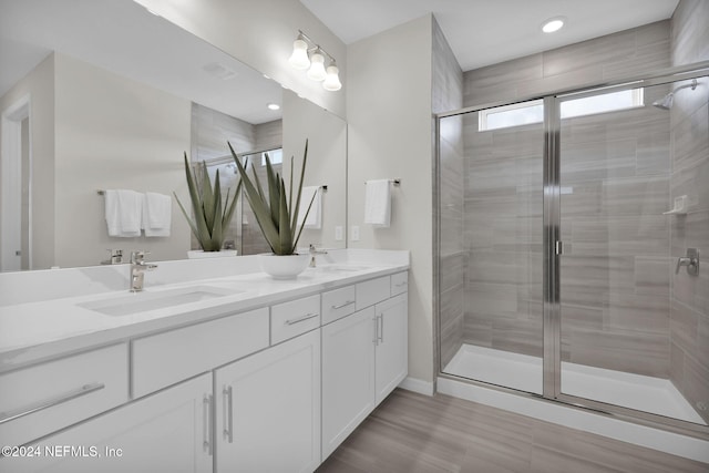 bathroom featuring vanity, hardwood / wood-style floors, and a shower with door