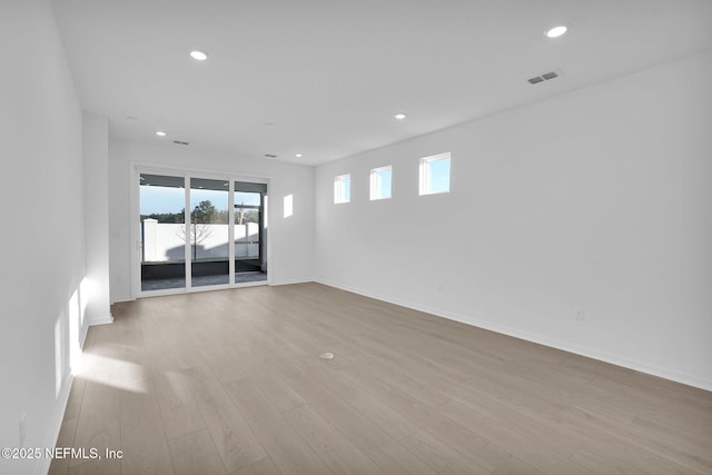 spare room with visible vents, recessed lighting, wood finished floors, and baseboards