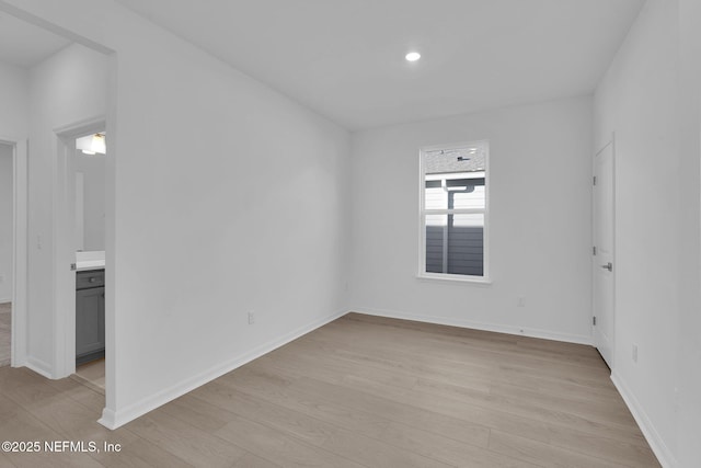 spare room with light wood-style flooring, recessed lighting, and baseboards