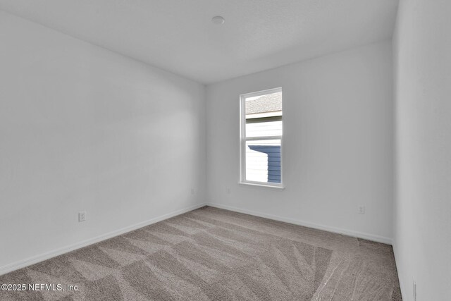 carpeted spare room with baseboards