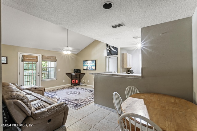 tiled living room with lofted ceiling, a textured ceiling, and ceiling fan