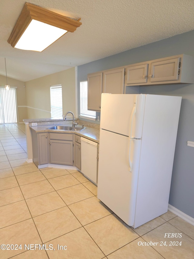 kitchen featuring light tile patterned floors, a textured ceiling, a skylight, sink, and white appliances