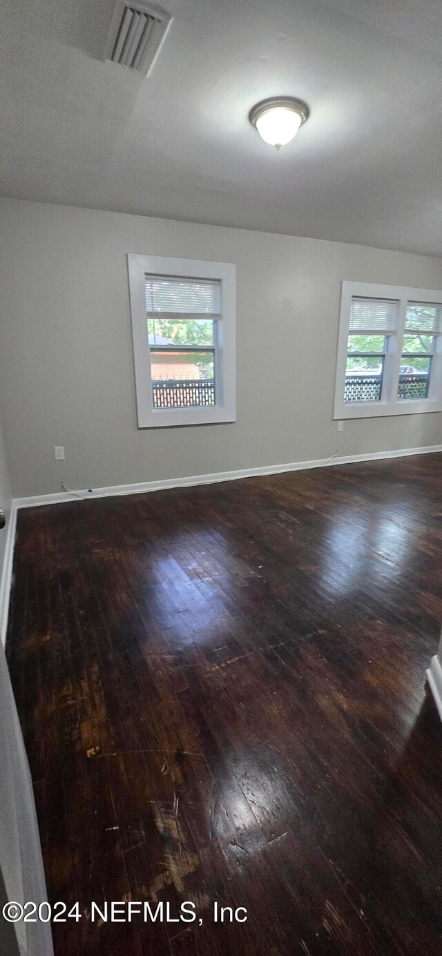 spare room with dark hardwood / wood-style floors and a healthy amount of sunlight