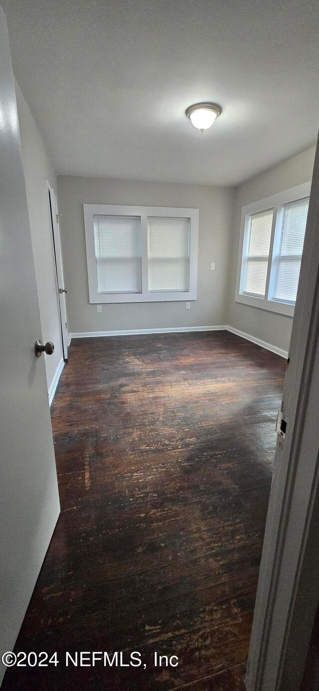 unfurnished room featuring dark wood-type flooring