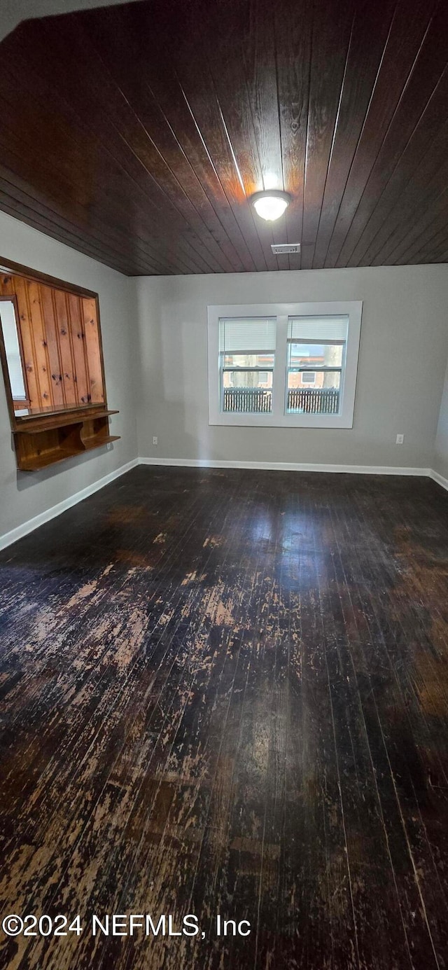 empty room with wooden ceiling and dark hardwood / wood-style flooring