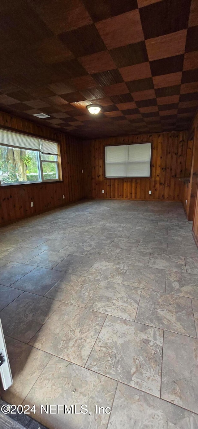 spare room featuring wood walls