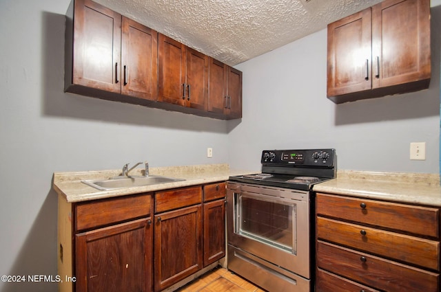 kitchen with sink, a textured ceiling, and stainless steel electric range oven