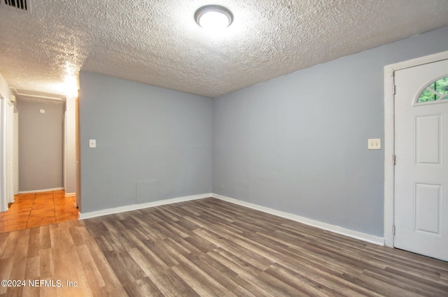 foyer entrance with a textured ceiling and dark hardwood / wood-style flooring