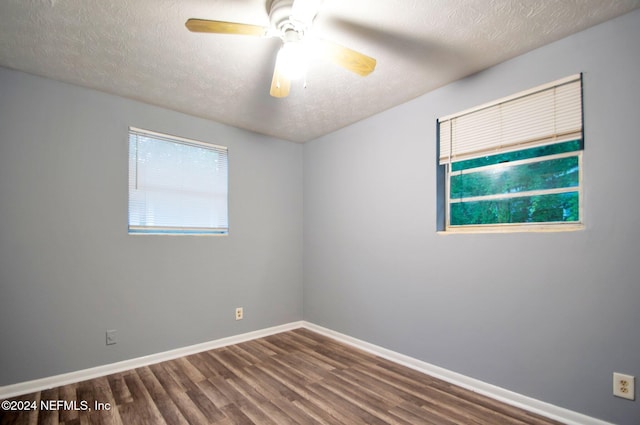 empty room with ceiling fan, wood-type flooring, and a textured ceiling