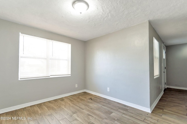 1526 W 14th St, Jacksonville, FL 32209 - empty room featuring light wood finished floors, a textured ceiling, and baseboards