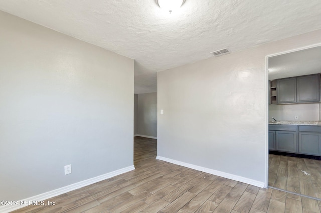 1526 W 14th St, Jacksonville, FL 32209 - empty room featuring light wood-style floors, visible vents, baseboards, and a textured ceiling
