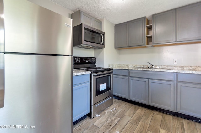 1526 W 14th St, Jacksonville, FL 32209 - kitchen with a sink, stainless steel appliances, gray cabinetry, and light wood-type flooring