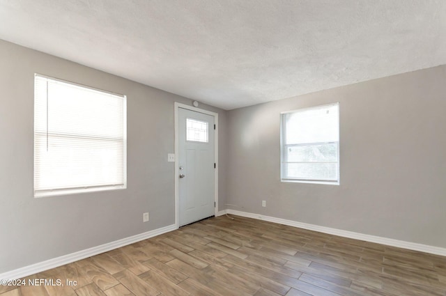 foyer entrance featuring a textured ceiling and light wood-type flooring