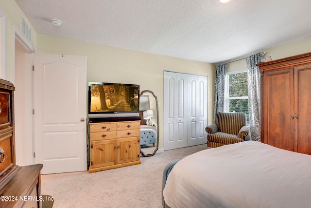 carpeted bedroom featuring a closet and a textured ceiling