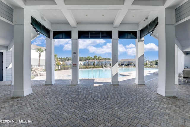 view of pool with a water view and a patio area