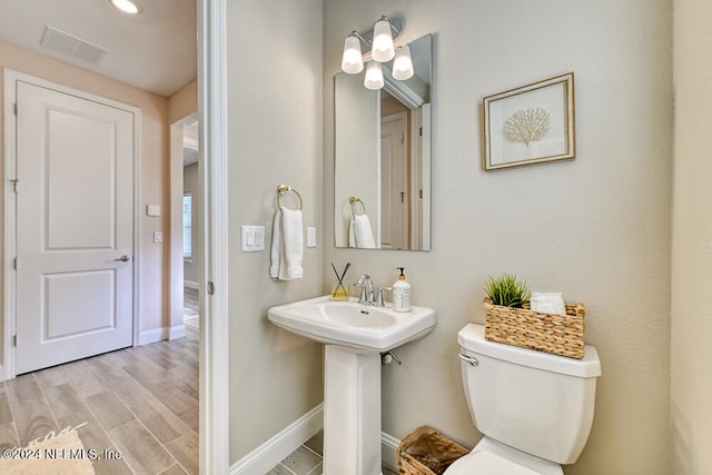 bathroom featuring hardwood / wood-style flooring and toilet