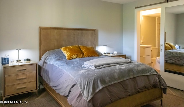 bedroom featuring a barn door and ensuite bath